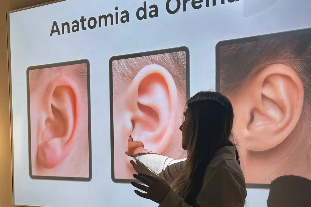 Bebê sorrindo com brinco na orelha, ilustrando o resultado prático e sem trauma ensinado no curso de furo humanizado